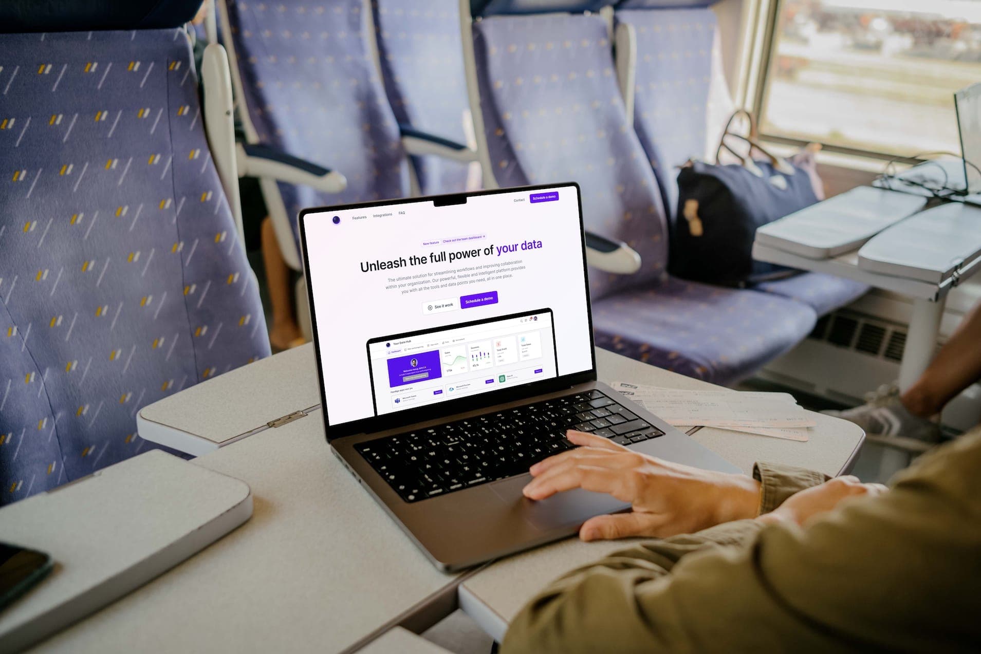 Iemand werkt in de trein op een laptop met de homepage van het dataplatform open.