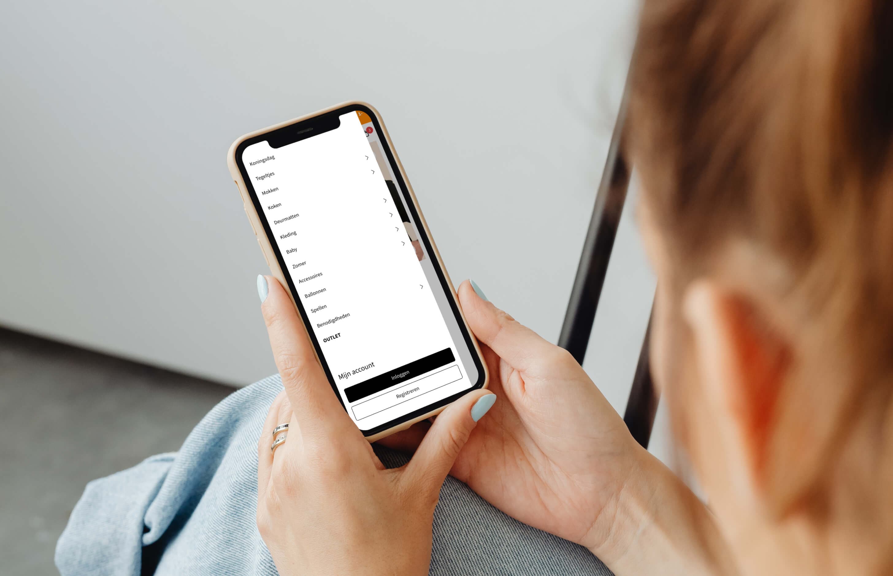 Iemand bladert op de telefoon door het uitgeklapte categoriemenu van de webshop.
