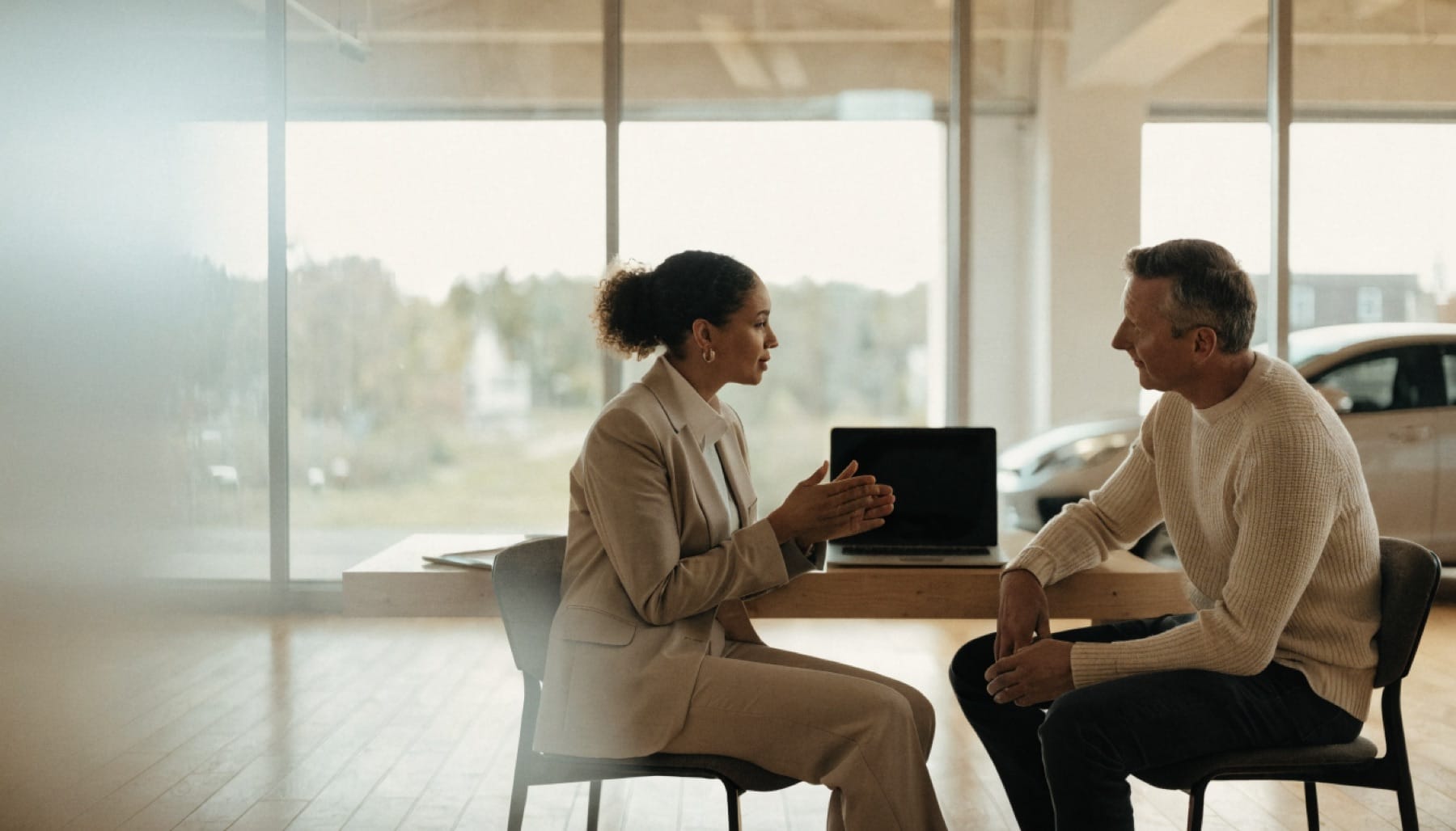Een leaseadviseur bespreekt een aanbod met een klant in de showroom